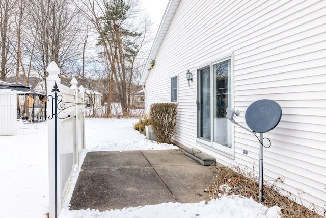 snow covered property with a patio area