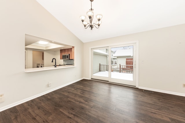 unfurnished dining area featuring lofted ceiling, dark hardwood / wood-style floors, a chandelier, and sink