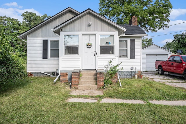 view of front of house with an outbuilding, a garage, and a front yard