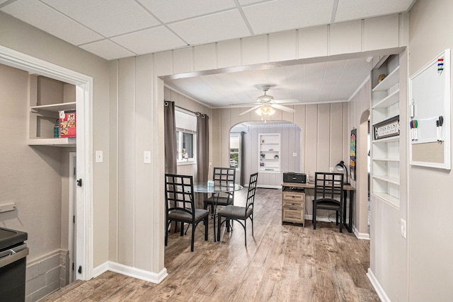 dining room featuring a drop ceiling, hardwood / wood-style flooring, and ceiling fan