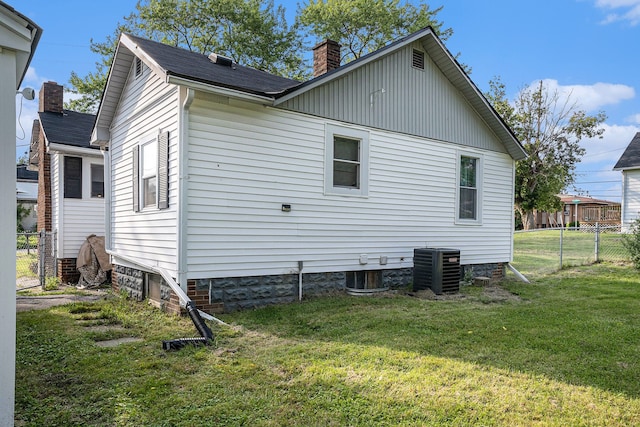 view of home's exterior with central AC unit and a yard