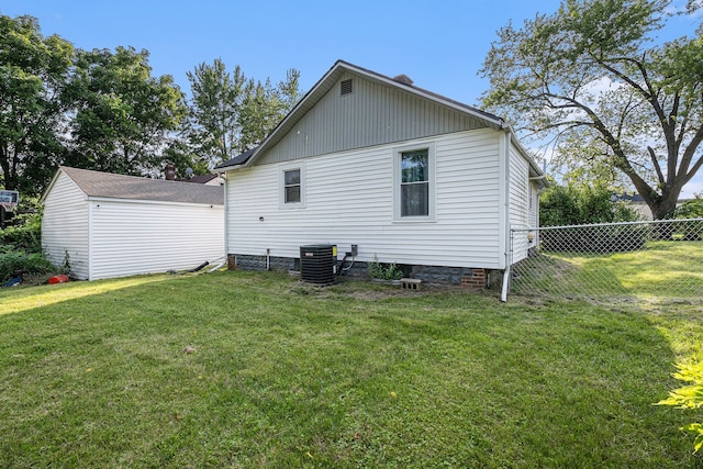 back of house with a lawn and central air condition unit