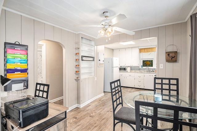 dining area featuring sink, ornamental molding, built in features, ceiling fan, and light hardwood / wood-style floors