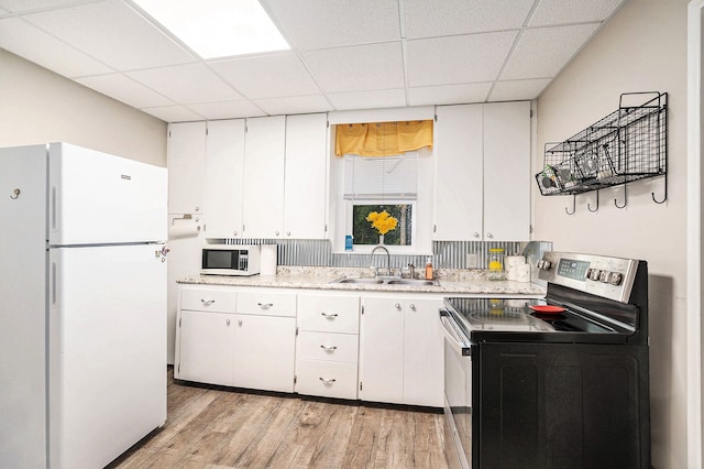 kitchen with white cabinets, white appliances, sink, and a drop ceiling