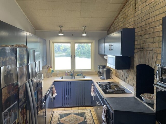 kitchen with black electric cooktop, sink, vaulted ceiling, and fridge