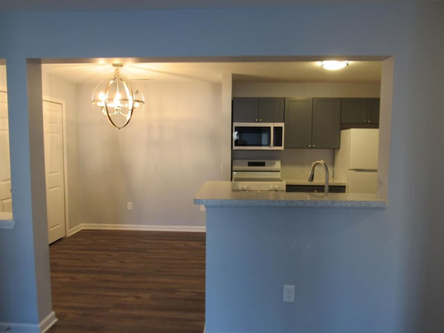 kitchen featuring white refrigerator, dark hardwood / wood-style floors, electric range, and kitchen peninsula