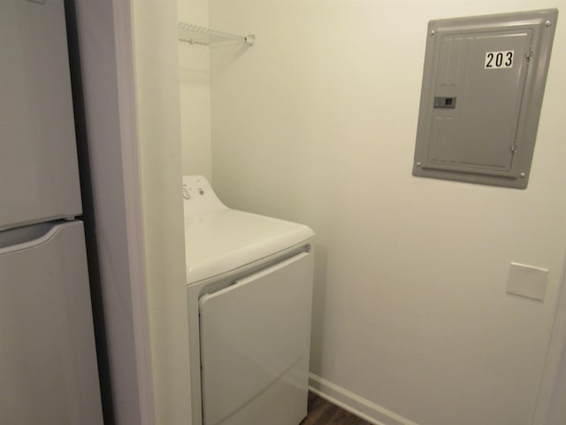 laundry room featuring dark hardwood / wood-style flooring, electric panel, and washing machine and dryer