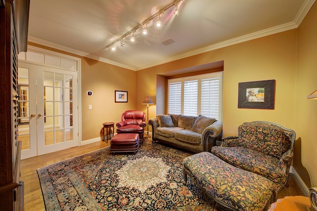 living room with french doors, crown molding, rail lighting, and light hardwood / wood-style flooring