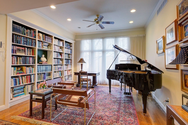 sitting room featuring ornamental molding, wood-type flooring, and ceiling fan