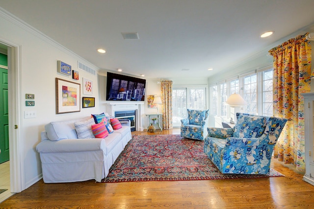 living room with crown molding and hardwood / wood-style flooring