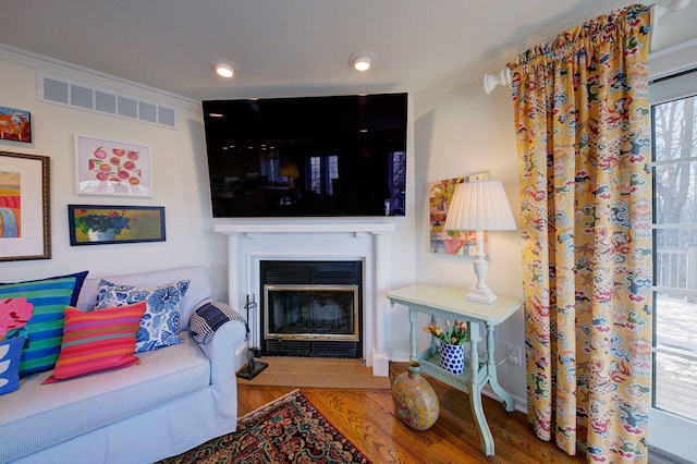 living room featuring light hardwood / wood-style flooring and ornamental molding