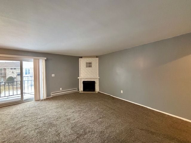 unfurnished living room with baseboard heating, carpet, and a brick fireplace