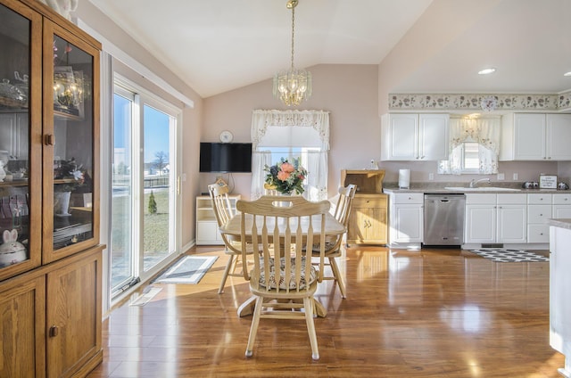 dining room with lofted ceiling, sink, a chandelier, and light hardwood / wood-style flooring