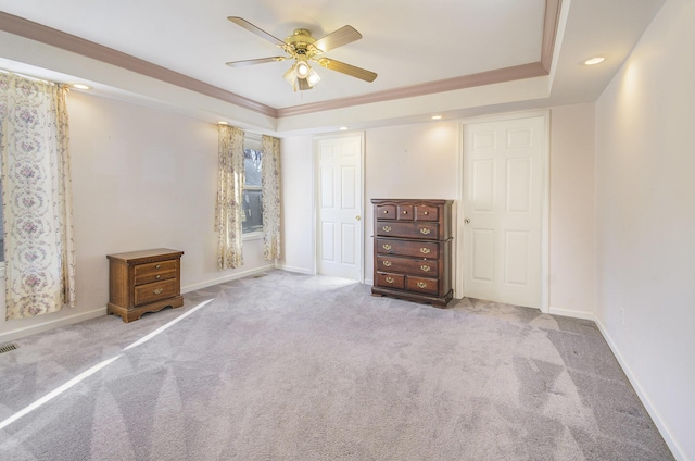 unfurnished bedroom with crown molding, ceiling fan, a raised ceiling, and light colored carpet