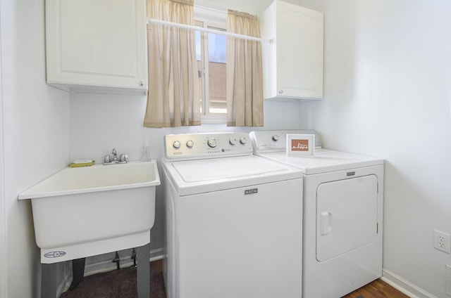 clothes washing area featuring sink, washing machine and dryer, and cabinets