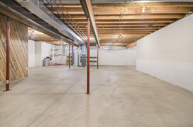 basement featuring electric panel and water heater