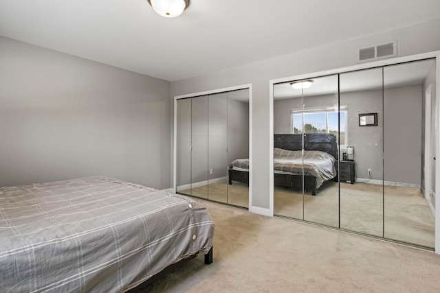 bedroom with carpet flooring and two closets