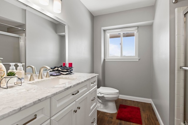 bathroom with walk in shower, vanity, toilet, and hardwood / wood-style floors