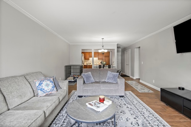 living room featuring hardwood / wood-style flooring, crown molding, and an inviting chandelier