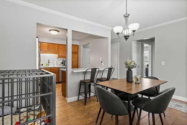 dining space with a notable chandelier, hardwood / wood-style flooring, and ornamental molding