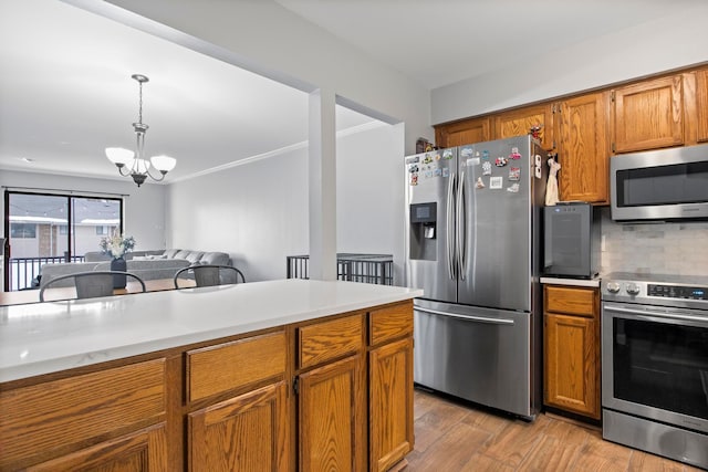 kitchen featuring decorative light fixtures, light hardwood / wood-style flooring, a notable chandelier, stainless steel appliances, and backsplash