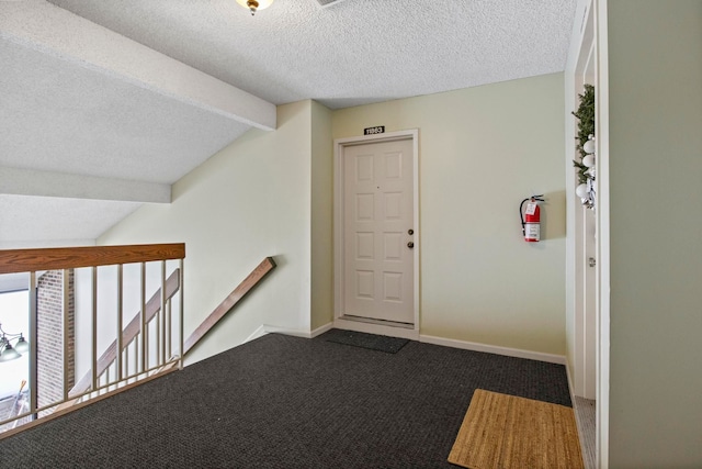 hall with carpet, vaulted ceiling with beams, and a textured ceiling