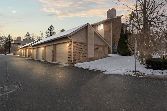 view of snowy exterior featuring a garage