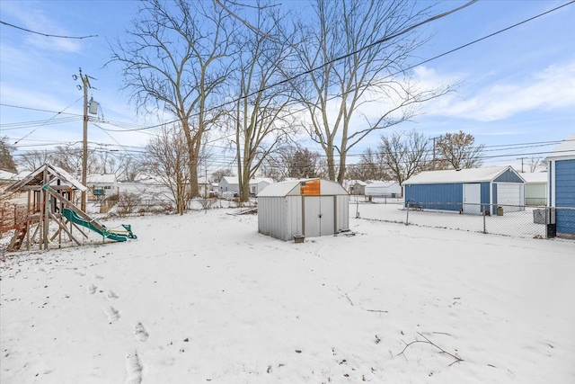 yard covered in snow featuring a shed and a playground