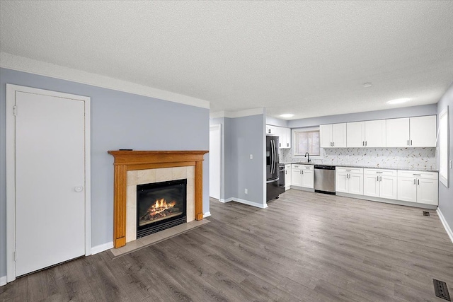 kitchen with white cabinetry, dishwasher, sink, wood-type flooring, and fridge