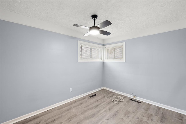 empty room with ceiling fan, a textured ceiling, and light wood-type flooring