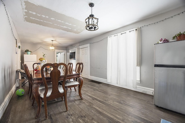 dining room with dark hardwood / wood-style flooring and a healthy amount of sunlight