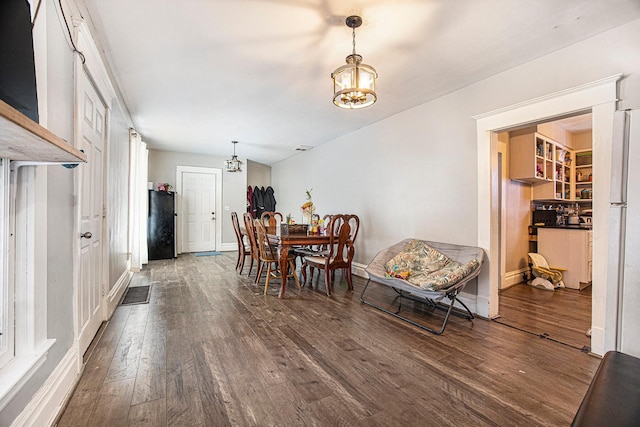 dining area featuring baseboards, dark wood-style flooring, and a chandelier