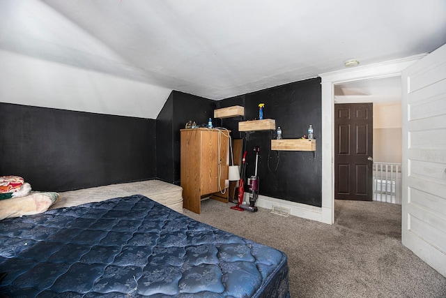 bedroom with carpet floors, baseboards, and lofted ceiling