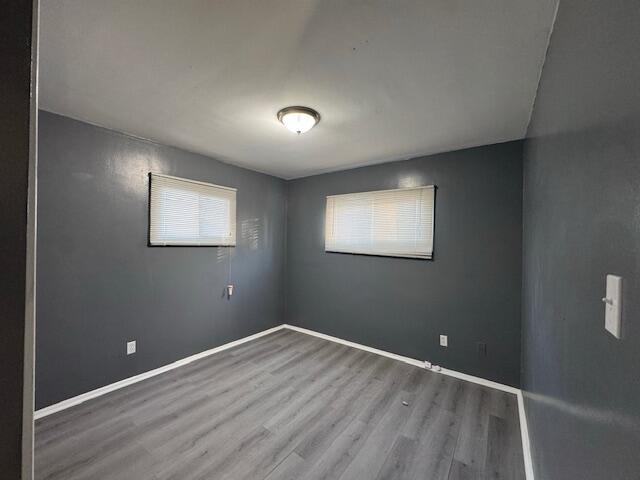 unfurnished room with wood-type flooring