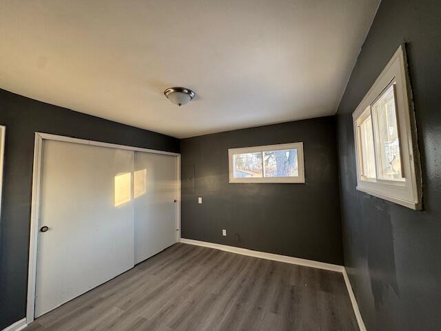 unfurnished bedroom featuring hardwood / wood-style floors and a closet