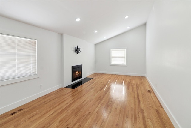 unfurnished living room featuring lofted ceiling and light hardwood / wood-style floors