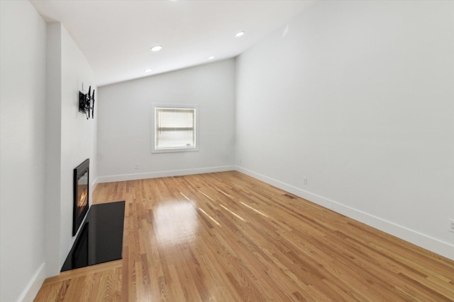 unfurnished living room with lofted ceiling and light hardwood / wood-style floors