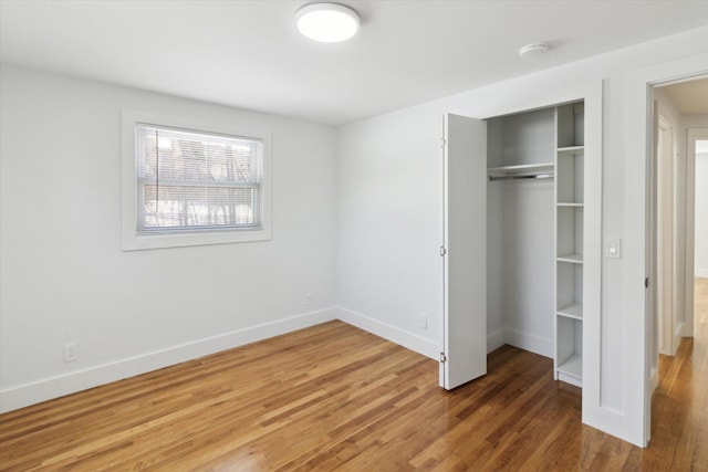 unfurnished bedroom with dark hardwood / wood-style floors and a closet