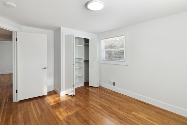 unfurnished bedroom featuring wood-type flooring and a closet