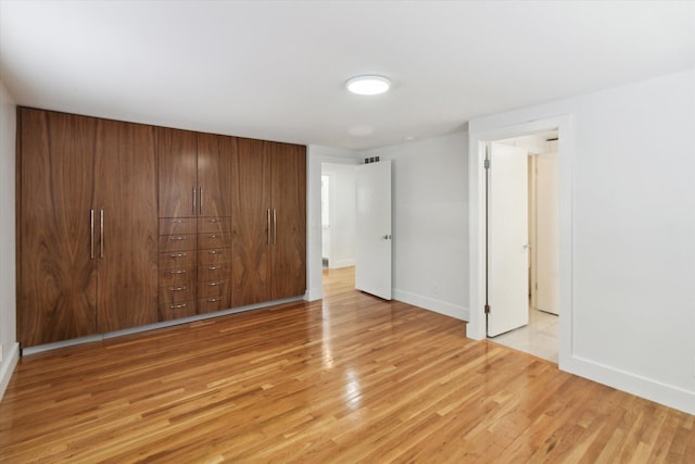 unfurnished bedroom with light hardwood / wood-style floors and a closet