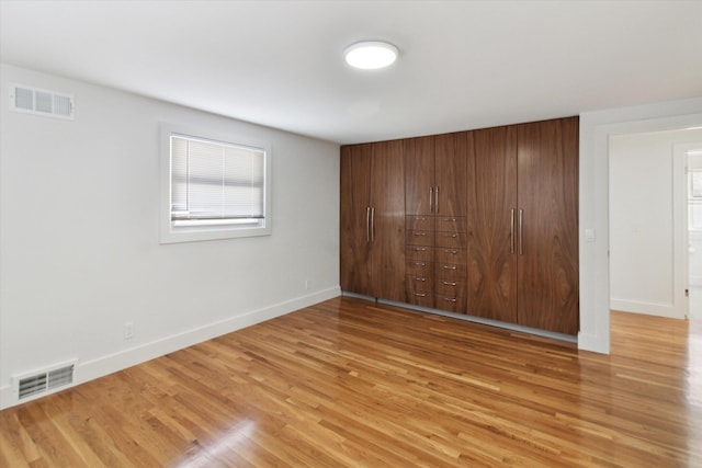 unfurnished bedroom with light hardwood / wood-style flooring and a closet