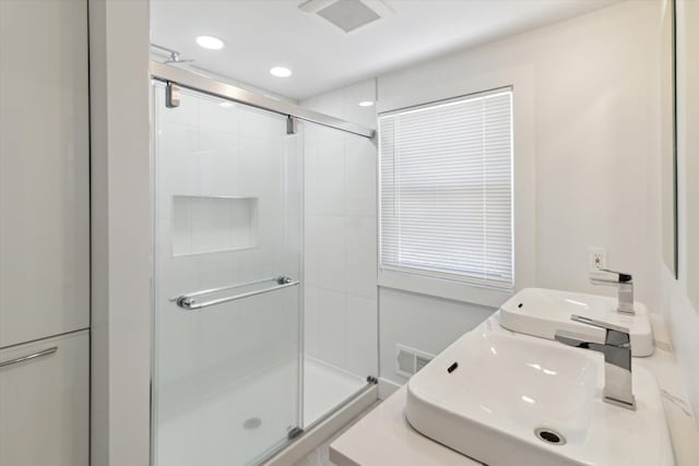 bathroom featuring walk in shower and vanity