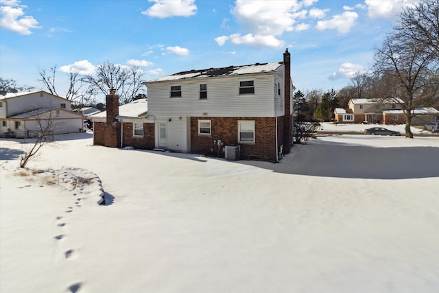 snow covered house with central AC