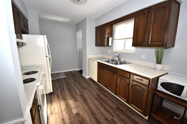 kitchen with white appliances, dark hardwood / wood-style floors, sink, and dark brown cabinets