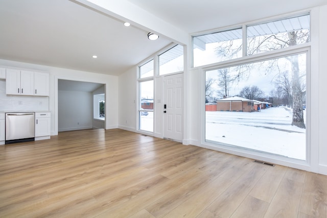 living room featuring lofted ceiling with beams and light hardwood / wood-style floors