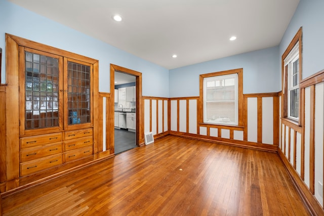 spare room with hardwood / wood-style flooring and sink