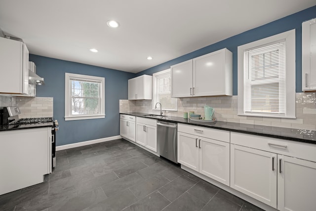 kitchen featuring sink, stainless steel appliances, a wealth of natural light, white cabinets, and wall chimney exhaust hood