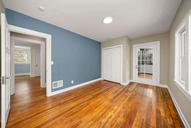 unfurnished bedroom with hardwood / wood-style flooring and a closet