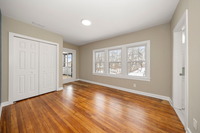 unfurnished bedroom featuring hardwood / wood-style flooring and a closet