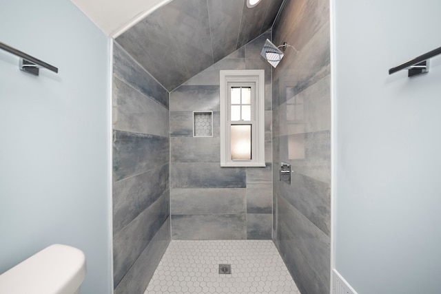 bathroom with tiled shower and toilet